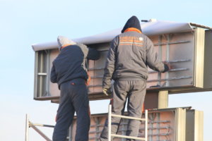 Installing LED modules on a flexible face sign.