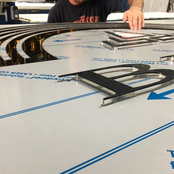 Embossed plexiglass letters on a golden sign