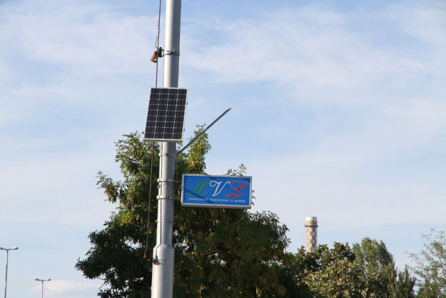 Illuminated sign with solar panel for street pole
