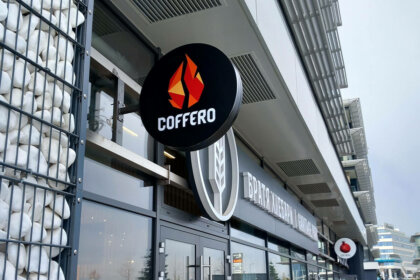 Round black sign with an illuminated Coffero logo
