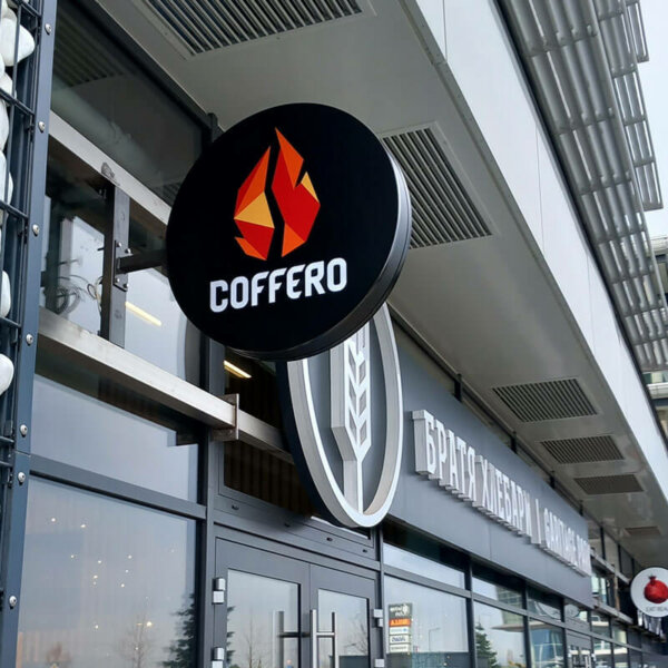 Round black sign with an illuminated Coffero logo Round black sign with an illuminated Coffero logo