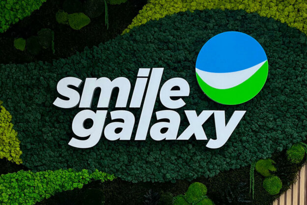 Smile Galaxy illuminated channel letters on a Scandinavian moss wall