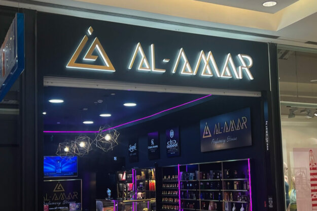 A sign for Al Amar store with illuminated emossed letters