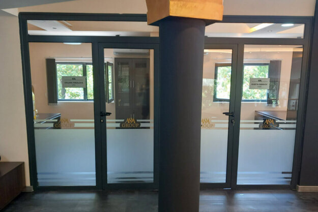 Wrapping showcases at office with frosted film and self-adhesive inscriptions