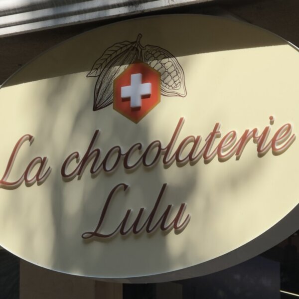 la-chocolaterie-lulu-plexiglass-sign-02 Елипсовидна табела с лого какаова шушулка и швейцарски кръст на La chocolaterie Lulu.